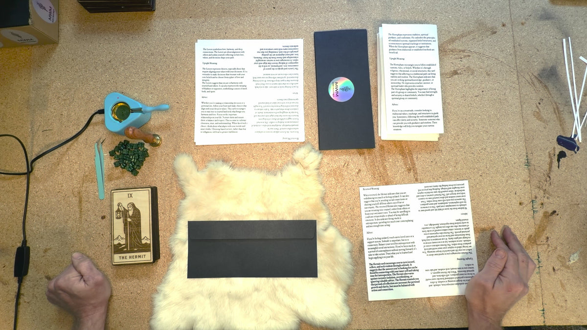 Man explaining the idea behind the Blind Tarot and packaging the wood cards into black envelopes and sealing with green wax.