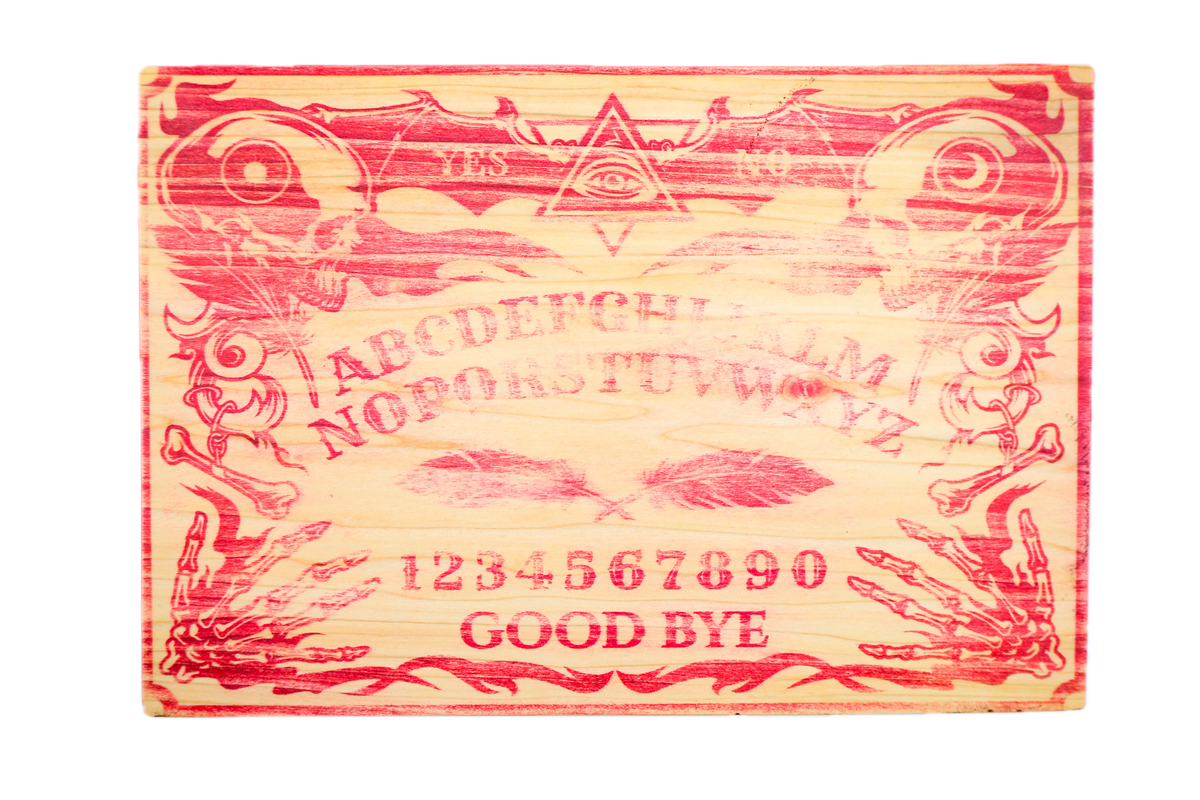 An egraved wooden Ouija board with red-painted details.
