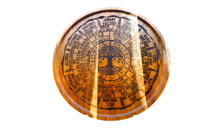 A round acacia tray engraved with all eight Sabbats, the Celtic tree calendar, and the year's named moons around a central Tree of Life.